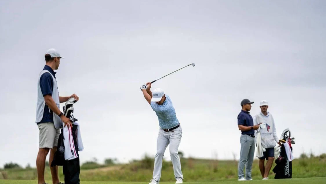 Two golfers training on a grass driving range at Beyond Golf Performance